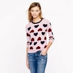 Carries pink heart sweater at Jcrew at J. Crew