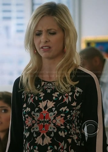 Sydney's black floral print blouse with striped sleeves on The Crazy Ones