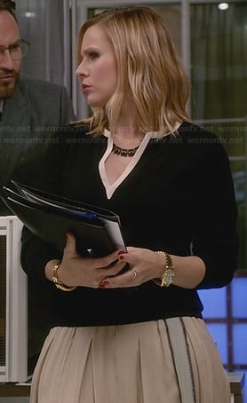 Jeannie's cream pleated skirt and black split-neck sweater on House of Lies