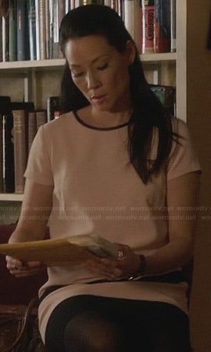 Joan's blush pink dress with black trim on Elementary