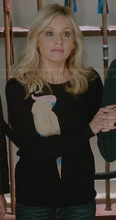 Sydney's black bird sweater and pink and red earrings on The Crazy Ones