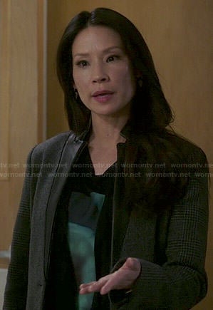 Joan's black top with green floral graphic and grey houndstooth coat on Elementary