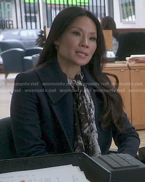 Joan's navy coat and black and white printed scarf on Elementary