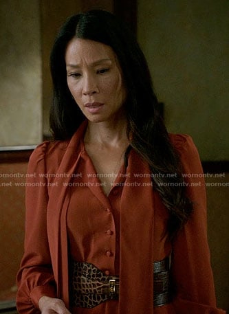Joan's orange tie neck dress and wide croc belt on Elementary