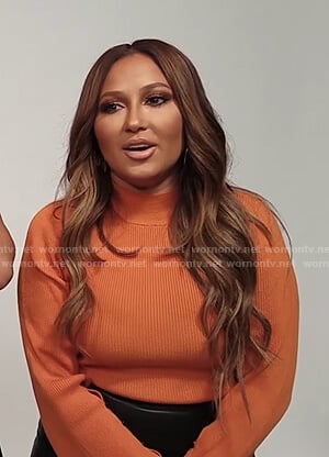 Adrienne's orange ribbed bell sleeve sweater on The Real