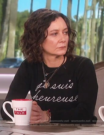 Sara's black Je Suis Heureuse sweater on The Talk