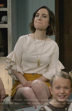 Jen's white ruffle top and yellow button skirt on Life in Pieces