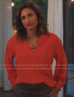 Emet's red v-neck blouse and green studded pants on I Feel Bad