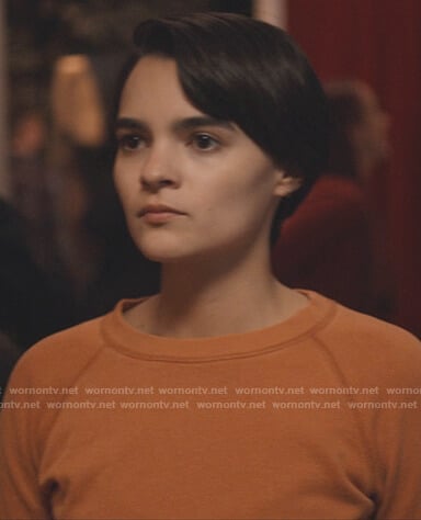 Elodie's orange sweatshirt on Trinkets