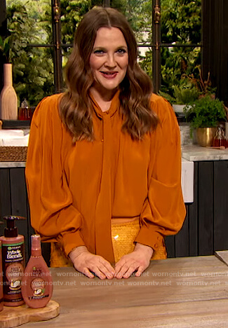 Drew's orange tie neck blouse and sequin skirt on The Drew Barrymore Show