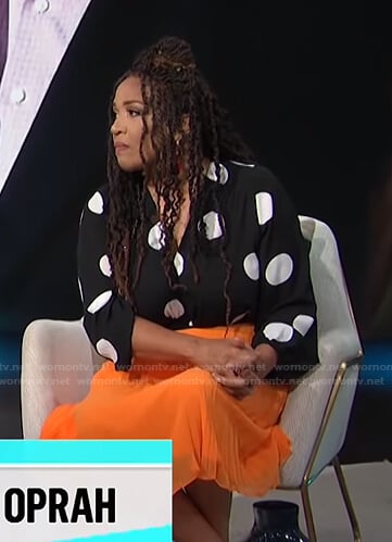 Kym's black polka dot top and orange pleated skirt on E! News Daily Pop