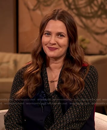 Drew's black printed tie neck blouse and beige pants on The Drew Barrymore Show