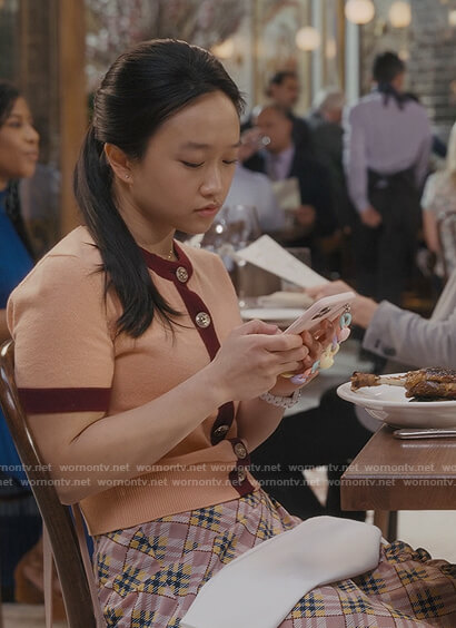 Lily's orange contrast trim cardigan and plaid skirt on And Just Like That