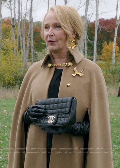 Nora's camel cape coat with chain detail on Inventing Anna