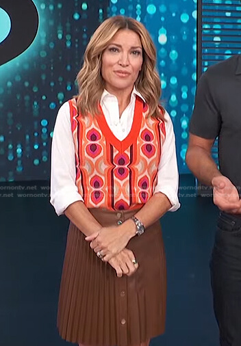 Kit's orange print vest and brown pleated skirt on Access Daily