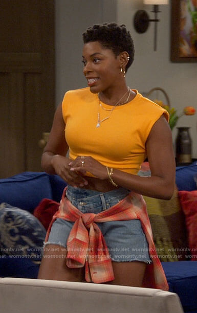 Necie's orange crop top and denim shorts on The Neighborhood