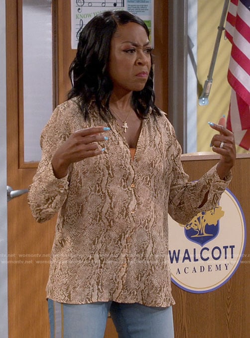 Tina's snake print blouse and side stripe jeans on The Neighborhood