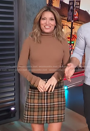 Kit's brown turtleneck top and plaid skirt on Access Hollywood