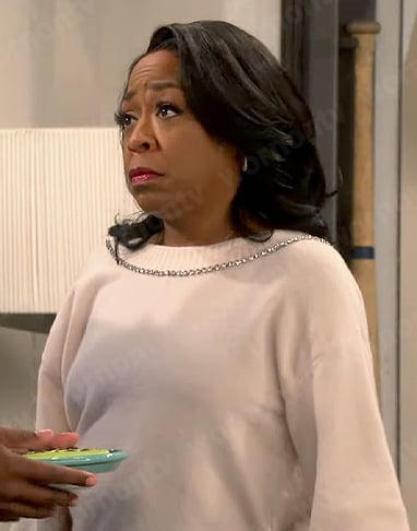 Tina's cream sweater with embellished trim and bow on The Neighborhood
