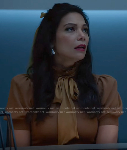 Helen's yellow puff-sleeve tie-neck top on True Lies