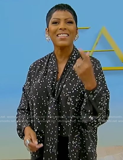 Tamron's black star print tie neck blouse on Tamron Hall Show