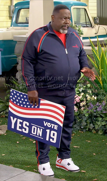 Calvin's navy tracksuit with red and green stripes on The Neighborhood