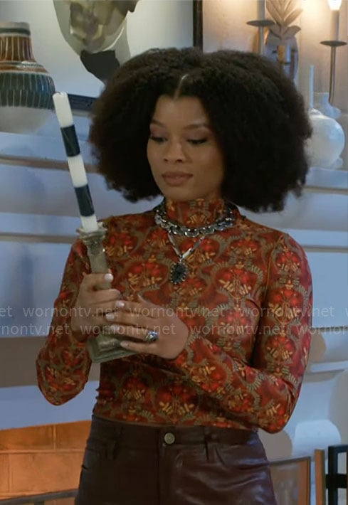 Eva's orange printed top on Beyond the Gates