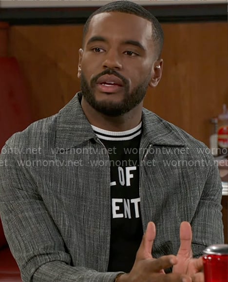 Andre's text t-shirt and grey jacket on Beyond the Gates