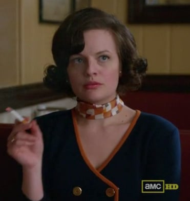Peggy’s navy sweater with orange trim and orange scarf on Mad Men