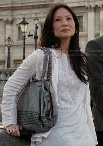 Joan’s white triangle inset tee and grey studded purse on Elementary