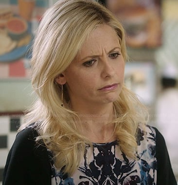 Sydney’s black and blue floral printed blouse and black drop earrings on The Crazy Ones