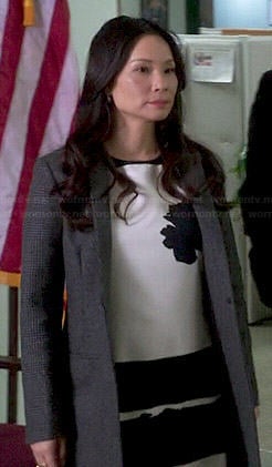 Joan’s black and white flower and stripe dress and grey coat on Elementary