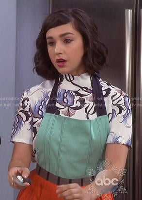 Mandy’s printed mock-neck top and mint/orange apron on Last Man Standing