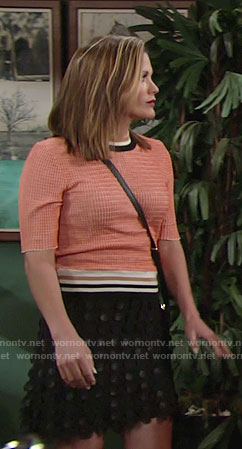 Chelsea’s orange top and black circle textured skirt on The Young and the Restless