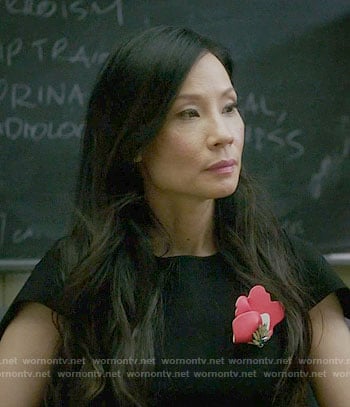 Joan’s black dress with red brooch on Elementary