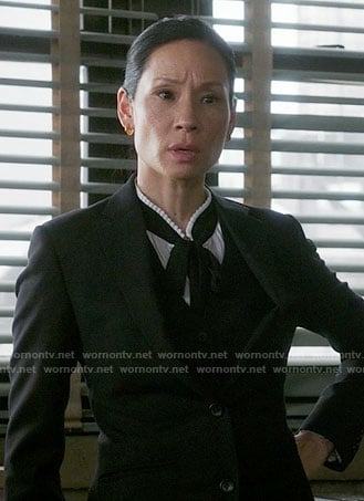 Joan’s white tie-neck blouse with pleated trim on Elementary