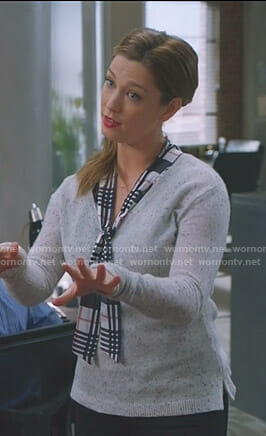 Katie’s plaid tie neck top and grey v-neck sweater on Great News