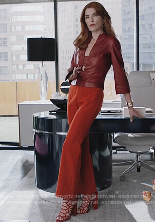 Kitty’s red leather split neck top and orange pants on Dietland