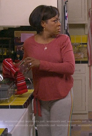 Tina’s orange tie-front tee and rainbow striped sweatpants on The Neighborhood
