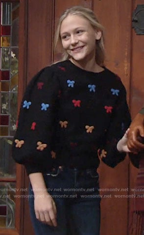 Faith’s black sweater with multi color bows on The Young and the Restless