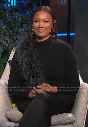 Garcelle’s black feather trim sweater and satin pants on E! News Daily Pop
