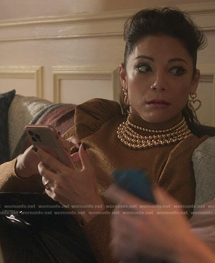Nikki’s gold puff sleeve turtleneck and heart earrings on She-Hulk Attorney at Law