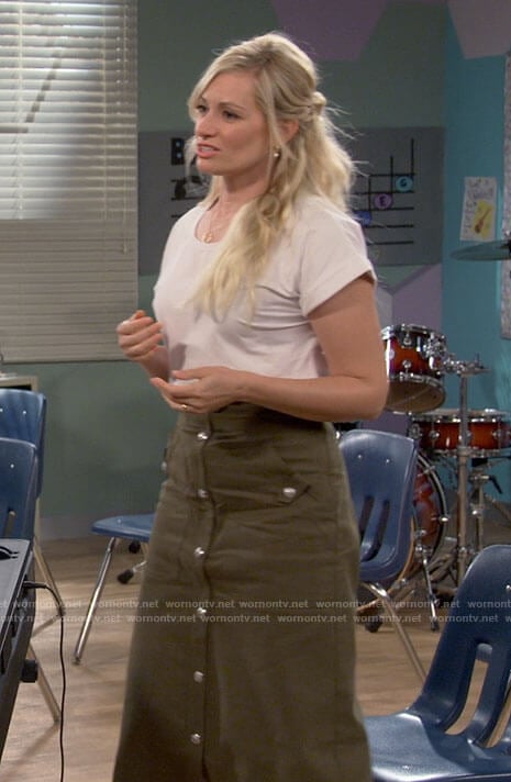 Gemma’s white tee and green button front skirt on The Neighborhood