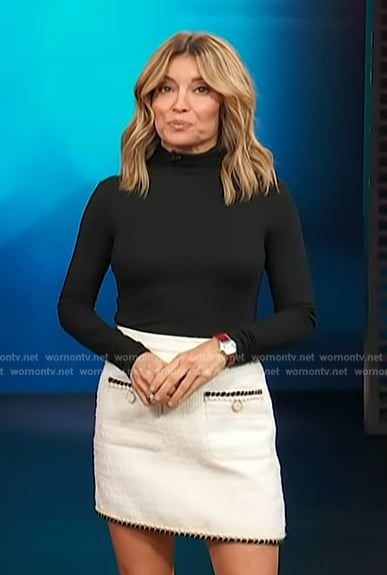 Kit’s black turtleneck sweater and white mini skirt on Access Hollywood