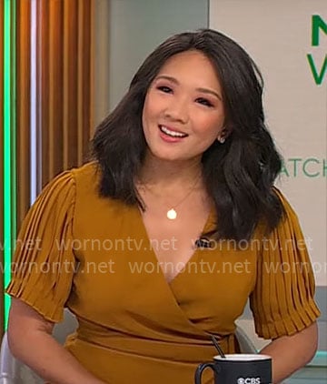 Nancy Chen’s mustard yellow pleated wrap dress on CBS Mornings