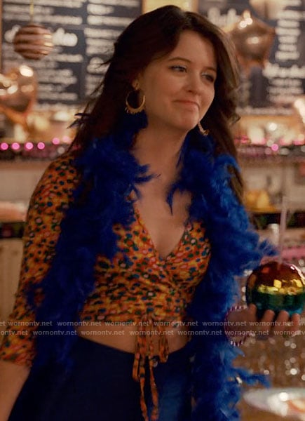 Maxine’s floral wrap top and metallic blue pants on Ginny & Georgia