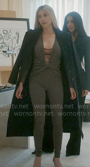 Anna’s grey twist front jumpsuit, lace bodysuit, silver clutch, and black coat on American Horror Story