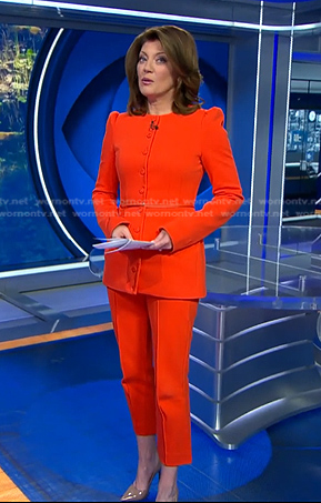 Norah’s orange belted jacket and cropped pants on CBS Evening News