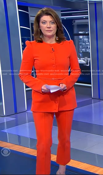 Norah’s orange belted jacket and cropped pants on CBS Evening News