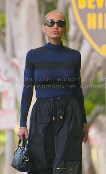 Mary’s blue and black striped turtleneck with black cargo skirt on Selling Sunset